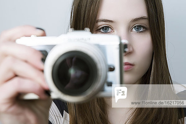 Portrait of Teenage girl holding digital camera