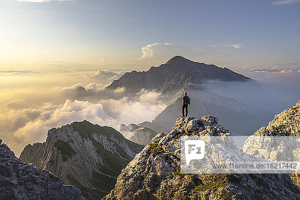 Wanderer  der auf einem Berggipfel in den Bergamasker Alpen  Italien  steht und die atemberaubende Aussicht bewundert