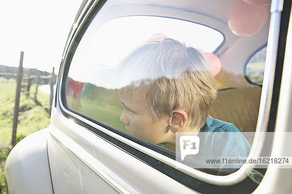Deutschland  Nordrhein-Westfalen  Köln  Junge im Auto schaut durch Fenster  Nahaufnahme