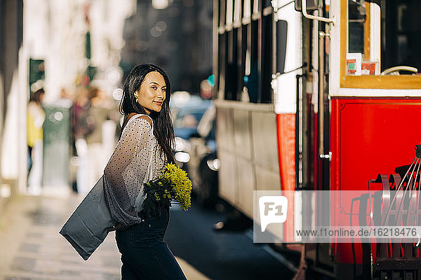 Junge Frau an der Straßenbahn in der Stadt