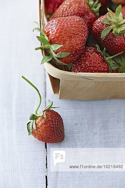Kiste mit Erdbeeren auf Holztisch  Nahaufnahme