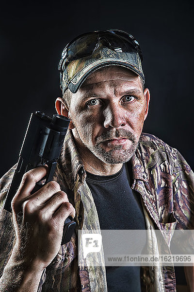 Porträt eines reifen Mannes mit Pistole  Nahaufnahme