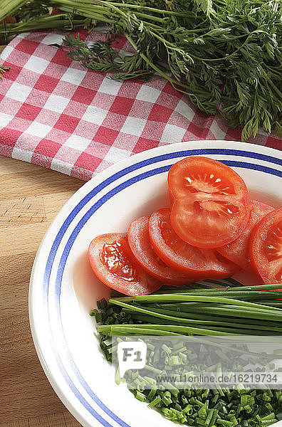 Tomaten,  Schnittlauch und Petersilie auf einem Teller,  Nahaufnahme