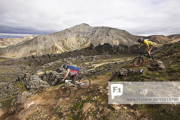 Iceland  Men mountain biking in hilly landscape