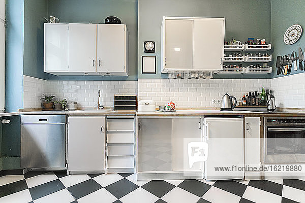 Tidy apartment kitchen with checkerboard floor
