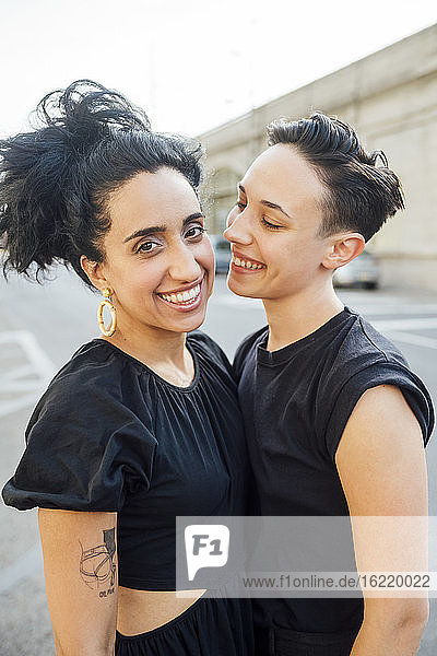 Lächelndes lesbisches Paar in der Stadt stehend