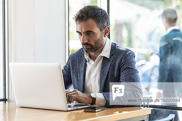 Businessman using laptop while sitting at table in cafe