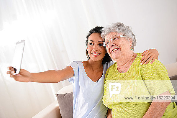 zwei Generation Frau jung und älter machen ein lustiges Selfie zusammen zu Hause