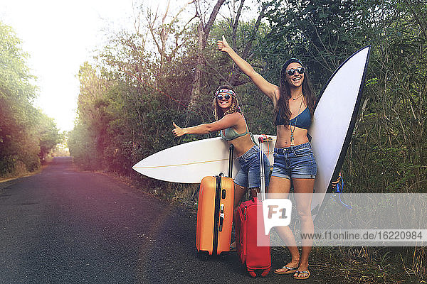 Mädchen mit einem Koffer. Junger und hübscher Hippie auf einer verlassenen Straße