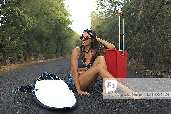 Girl with a suitcase. Young and Pretty Hippie on a Deserted Road