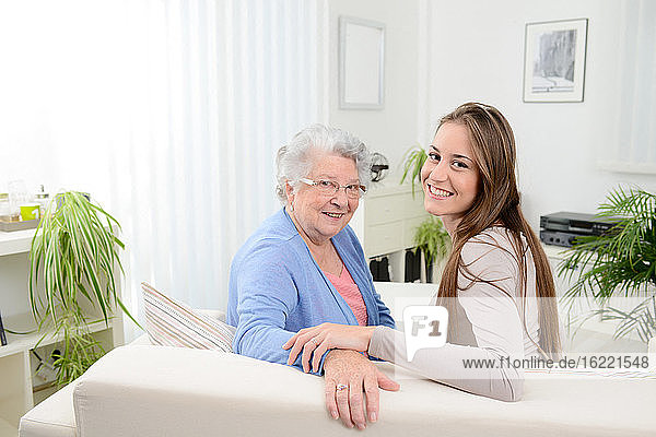 alte ältere Frau zu Hause mit fröhlichem jungen Mädchen verbringt Zeit zusammen