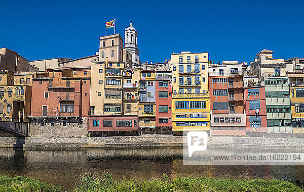 Spanien Katalonien  Girona  Fluss Onyar  bunte Fassaden der Altstadt  Fahne und Glockenturm der Kathedrale von Girona