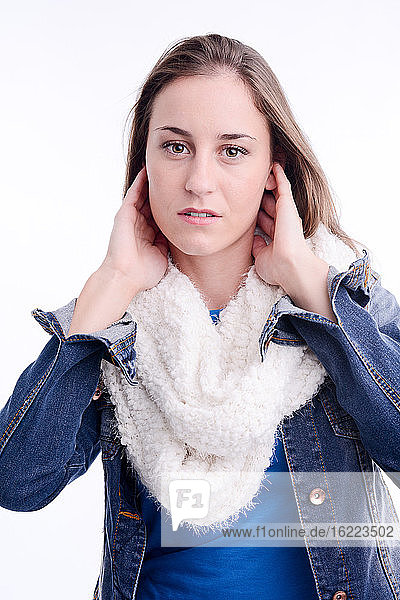 Sexy schöne junge Frau Modell posiert im Studio mit blauer Jeansjacke und Schal auf weißem Hintergrund.