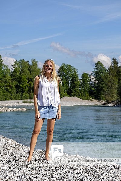 Portrait young blonde woman  miniskirt  at the water  summer  Bavaria  Germany  Europe