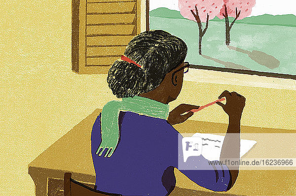 Frau schreibt am Schreibtisch und schaut aus dem Fenster