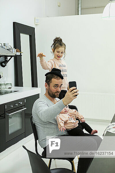 Vater mit Kindern beim Selfie