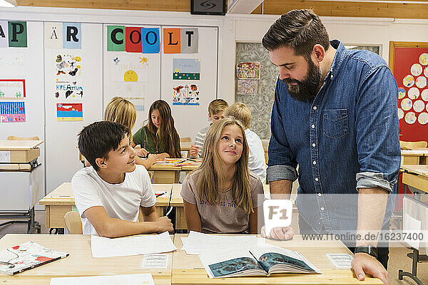 Lehrerin hilft Kindern im Klassenzimmer