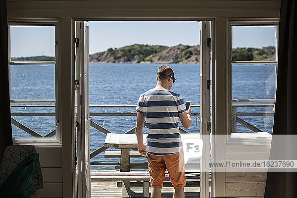 Man standing on patio at sea