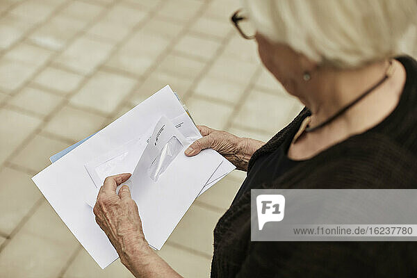 Ältere Frau hält Briefe