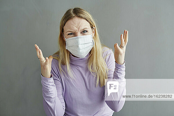 Angry woman wearing protective mask