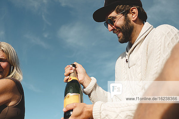 Smiling man holding champagne bottle