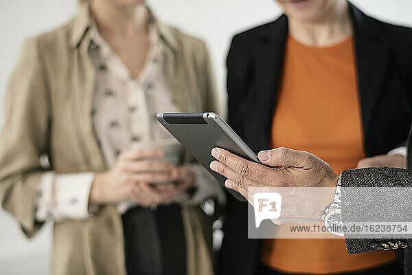 Geschäftsleute halten ein digitales Tablet in der Hand