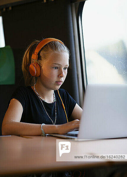 Mädchen im Zug mit Laptop