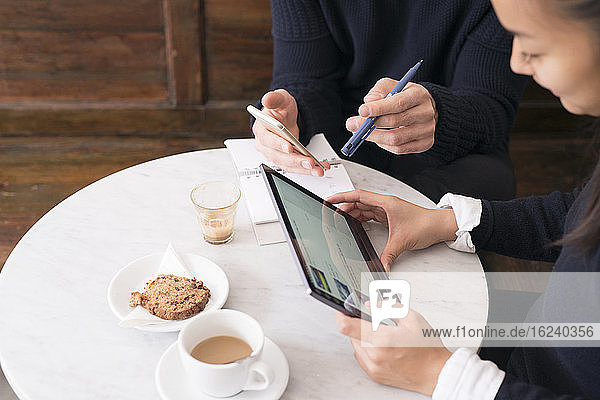 Paar in einem Café mit digitalen Geräten