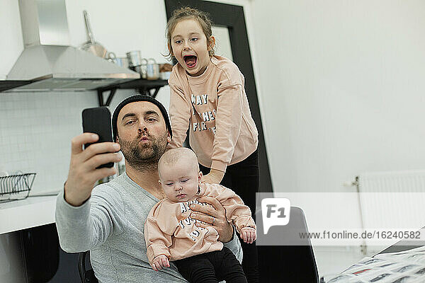 Vater mit Kindern beim Selfie
