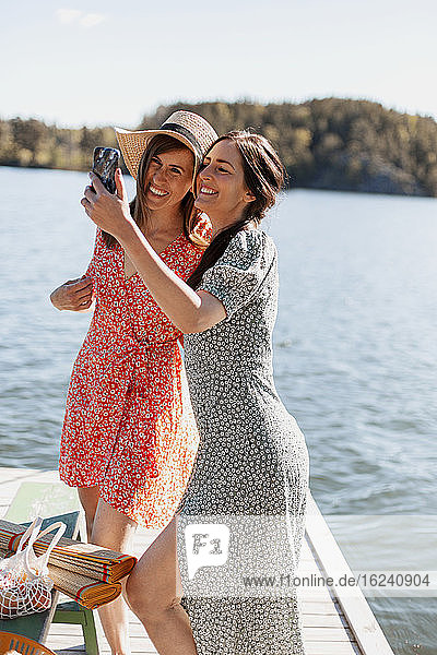 Glückliche Freundinnen machen ein Selfie auf dem Steg
