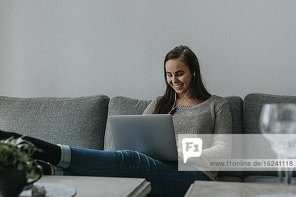 Frau auf Sofa mit Laptop