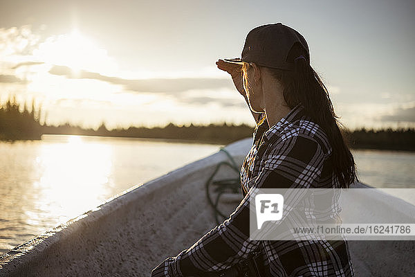 Frau auf Boot mit Blick auf den See