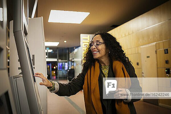 Woman buying tickets in ticket machine