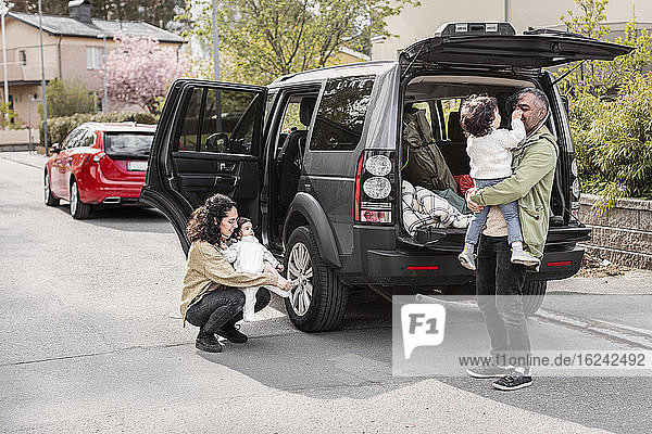 Parents with children near car