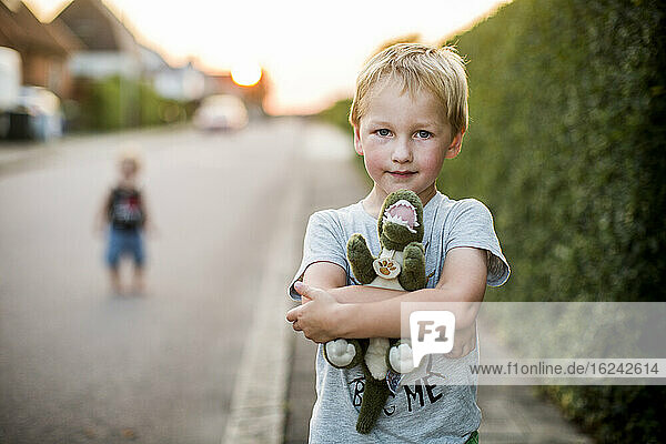 Boy holding stuffed dinosaur