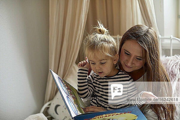 Mutter mit Tochter  die ein Buch liest