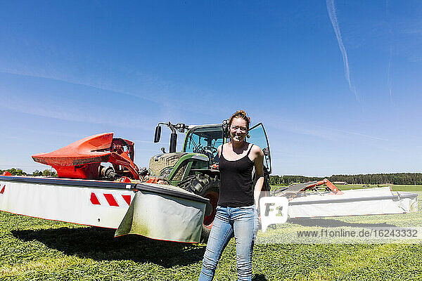 Frau vor einem Traktor stehend