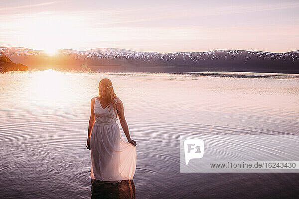 Woman in lake at sunset