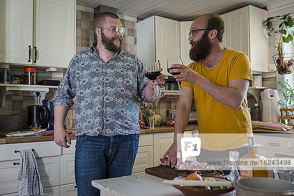 Men in kitchen having wine