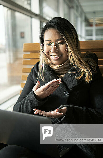 Woman at train station using laptop