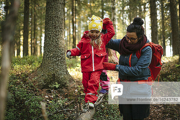Mutter mit Tochter geht durch den Wald