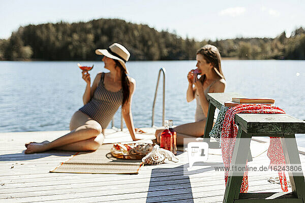 Female friends relaxing on jetty
