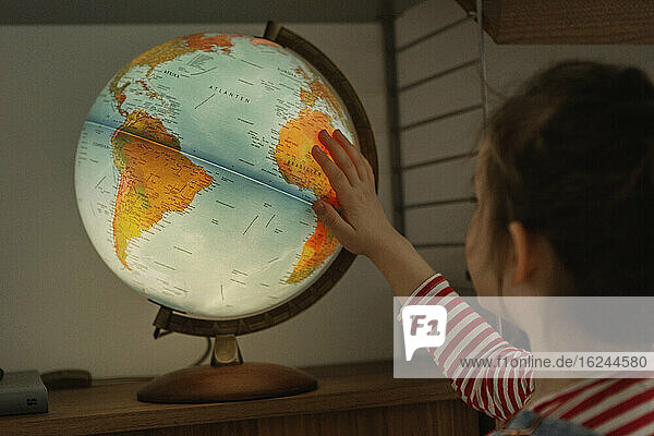 Mädchen schaut auf Globus