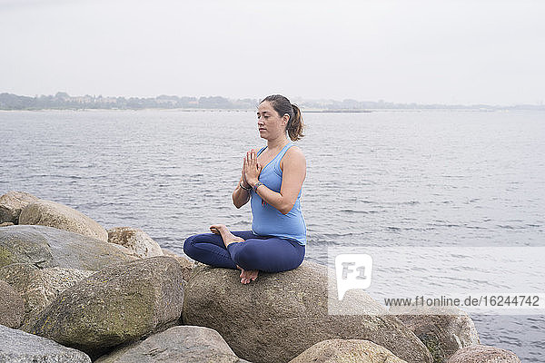 Frau meditiert auf See