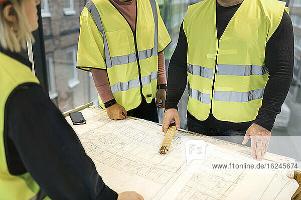 Arbeiter bei der Überprüfung eines Bauplans auf der Baustelle