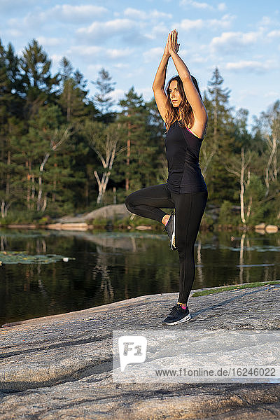 Frau am See beim Yoga