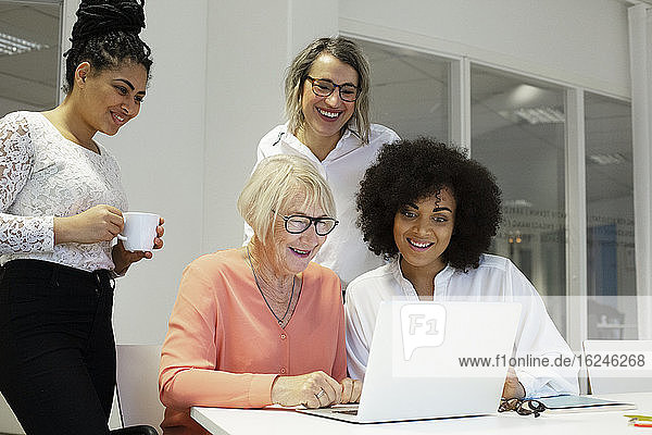 Women at business meeting using laptop