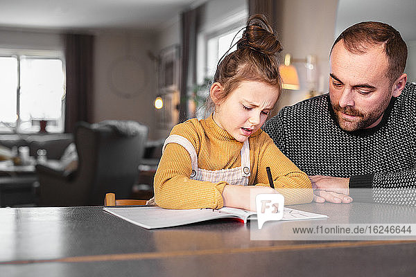 Vater hilft Tochter bei den Hausaufgaben