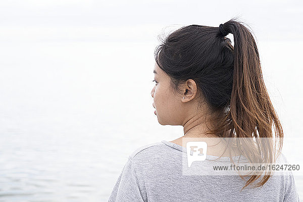 Junge Frau schaut auf das Meer