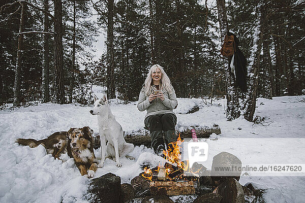 Frau sitzt am Kaminfeuer im Winter